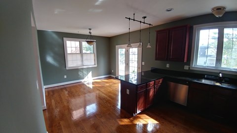 A kitchen with dark wood cabinets and a stainless steel sink.