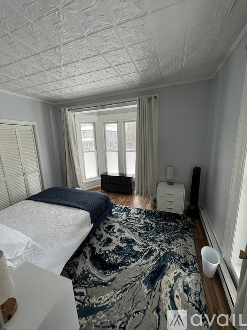 A bedroom with a bed, dresser, and window.