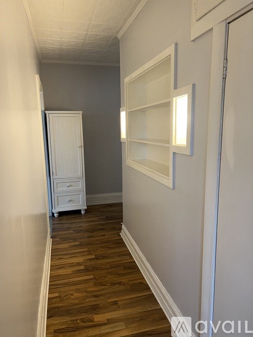 A hallway with a white door and a white cabinet.