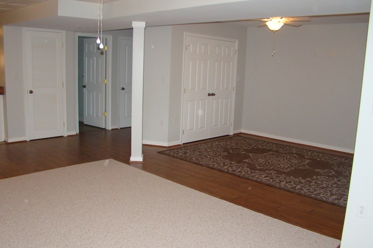 A room with a rug and a door.