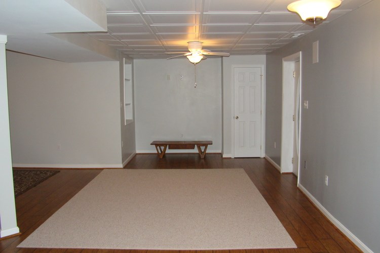 A room with a rug and a bench.