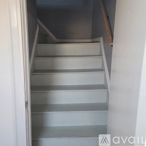 A staircase with a white railing and grey steps.