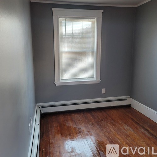 A room with a window and wooden floors.