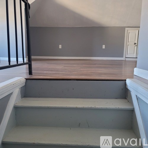 A room with wooden flooring and a white door.