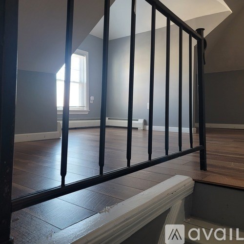 A black metal railing on a wooden floor.