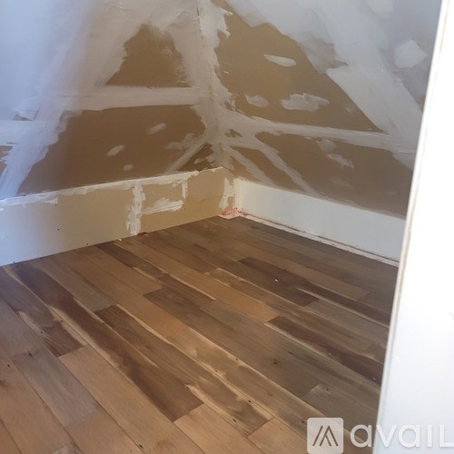 A room with wooden flooring and walls under renovation.