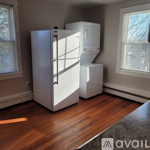 A white refrigerator and freezer in a room with wooden floors.