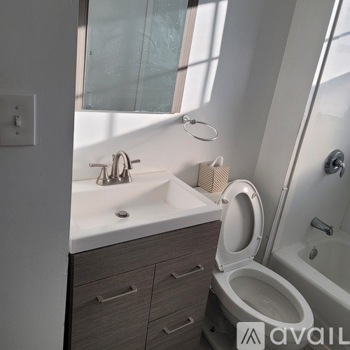 A modern bathroom with a toilet, sink, and bathtub.