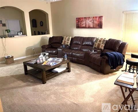 A living room with a brown leather couch and a coffee table.