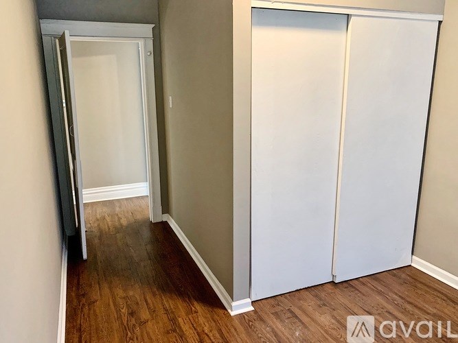 A room with a white door and a white wardrobe.