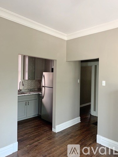 A kitchen with a refrigerator, sink, and cabinets.