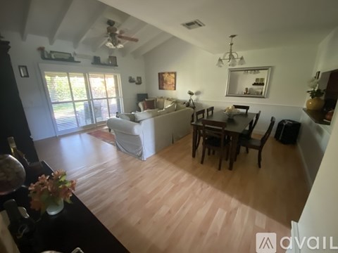 A living room with a white couch and a wooden floor.