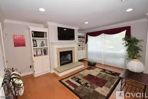 A living room with a fireplace and a television on the wall.