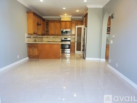 A kitchen with wooden cabinets and a tiled floor.