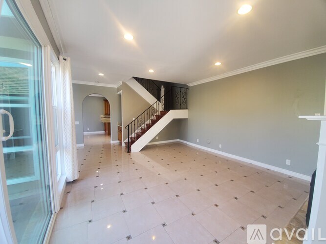 A spacious room with a staircase and tiled flooring.