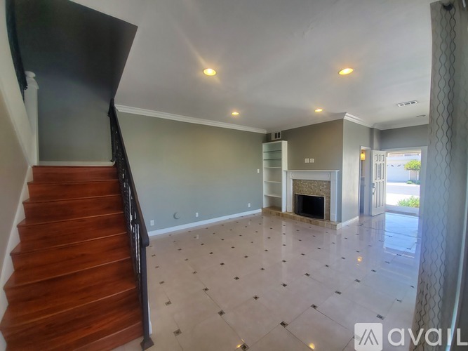 A living room with a fireplace and a staircase.