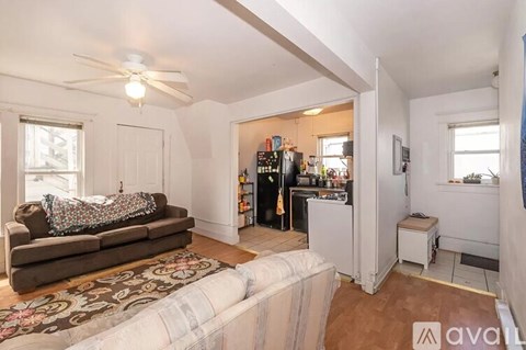 A living room with a couch and a fan.