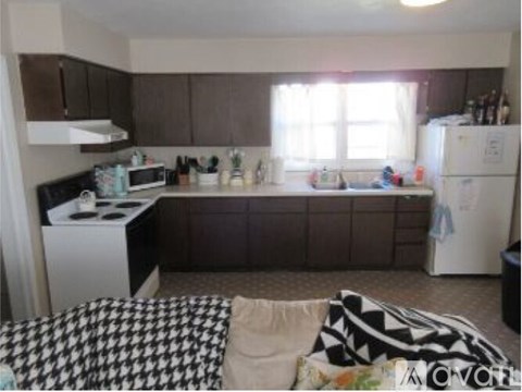 A kitchen with a white stove and a white refrigerator.