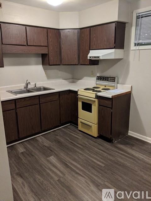 A kitchen with wooden cabinets and a yellow stove.