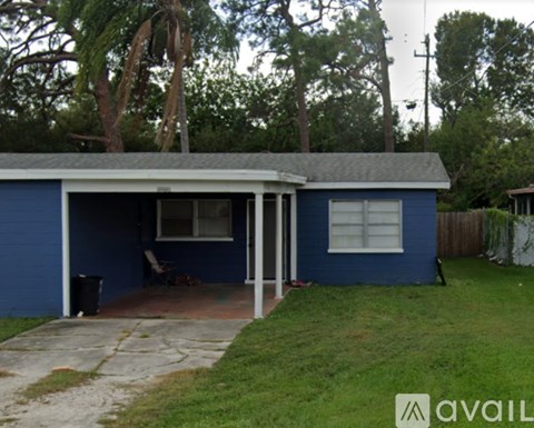 A blue house with a patio and a trash can.
