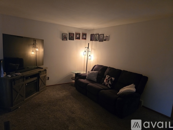 A living room with a black couch and a television.