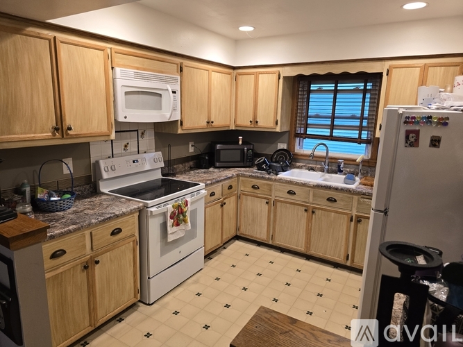 A kitchen with wooden cabinets and a white fridge.