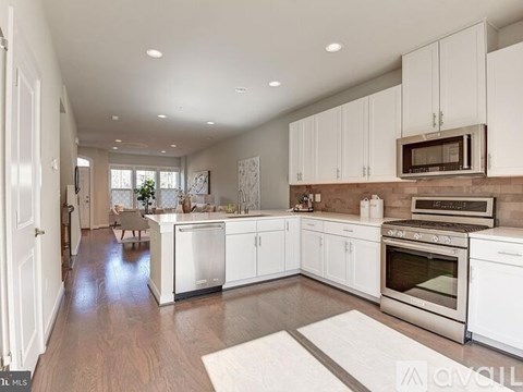A kitchen with white cabinets and stainless steel appliances.
