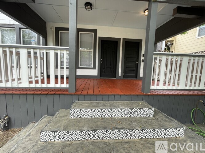 A house with a black door and a wooden deck.