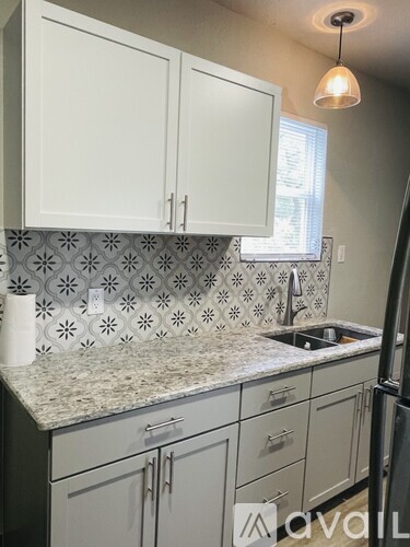 A kitchen with white cabinets and a granite countertop.