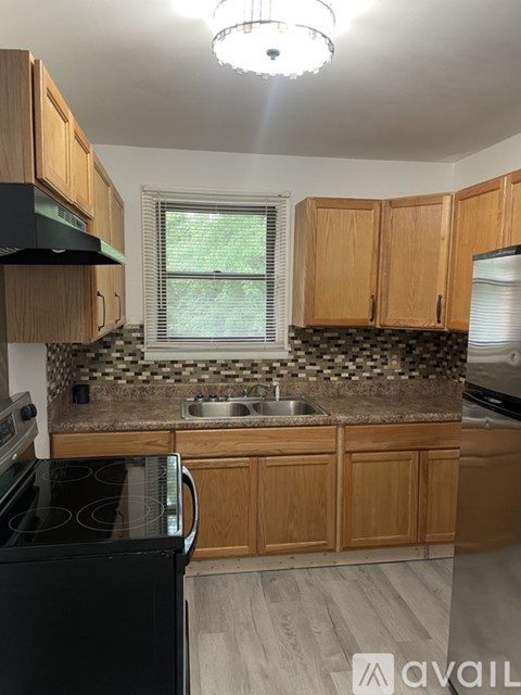 A kitchen with wooden cabinets and a black stove top oven.