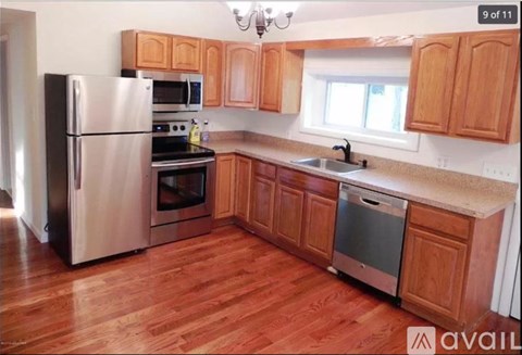 A kitchen with wooden cabinets and a stainless steel refrigerator.