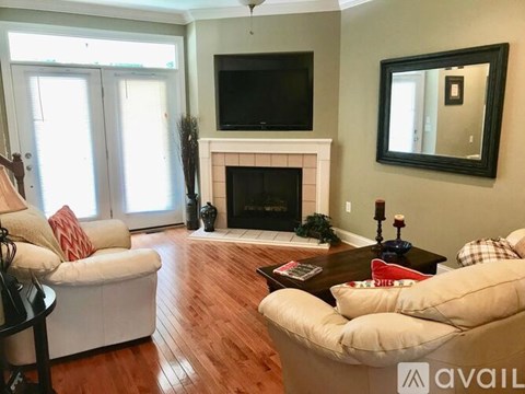 A living room with a fireplace and a television above it.