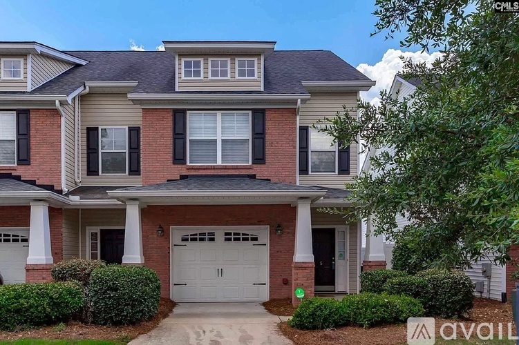 A two-story house with a garage and a driveway.