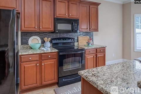 A kitchen with brown cabinets and granite countertops.