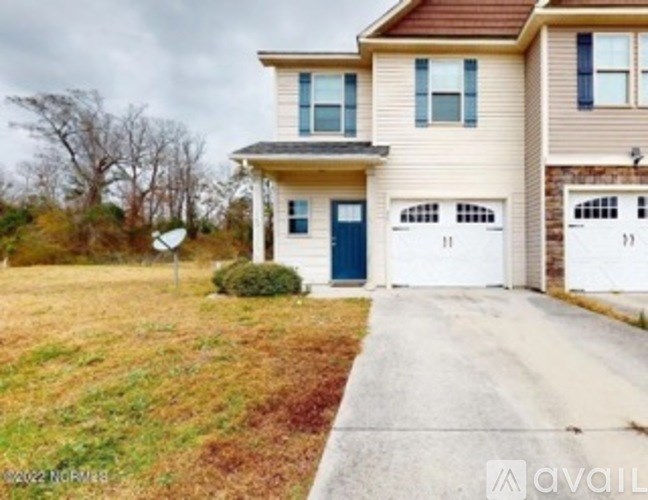 A two-story house with a garage is available for sale.