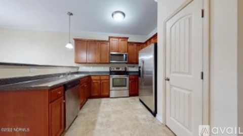 A kitchen with brown cabinets and a black countertop.