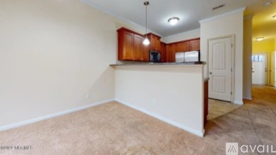 A room with a white wall and a brown cabinet.