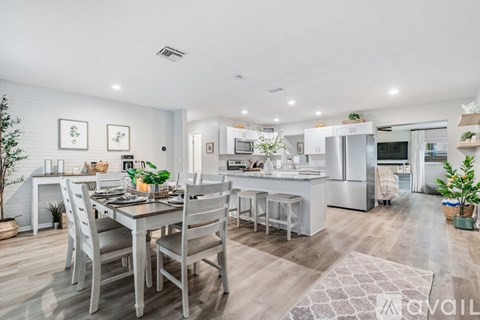 A modern kitchen with a dining table set for four.