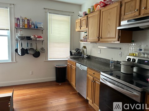 A kitchen with wooden cabinets and a black countertop.