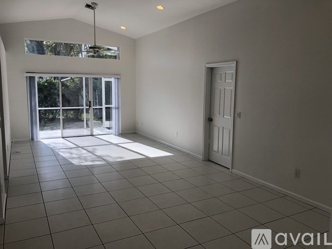 A spacious room with a sliding glass door leading to a balcony.
