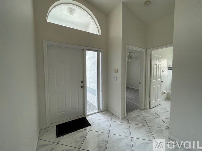 A room with a window and a hanging light fixture.