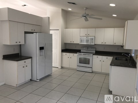 A kitchen with white cabinets and appliances.