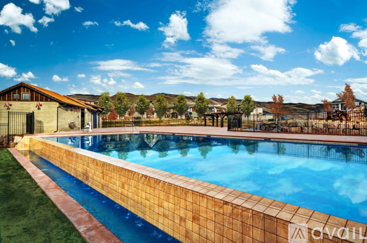 A large outdoor swimming pool surrounded by a brick border.