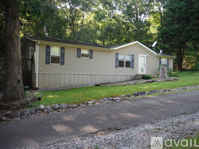 A house with a gravel driveway in front of it.