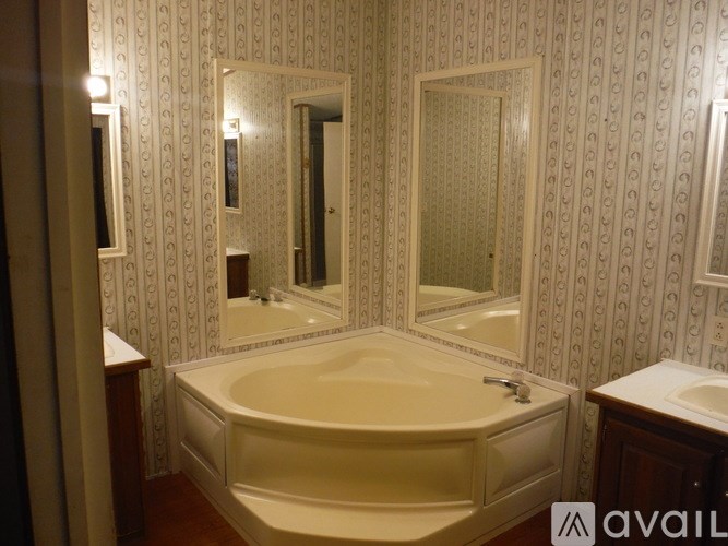 A bathroom with a large tub and a patterned wallpaper.