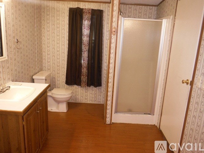 A bathroom with a toilet, sink, and shower.