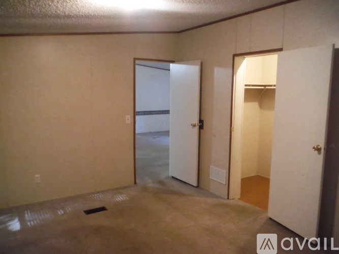 A room with a door and a wall shelf.