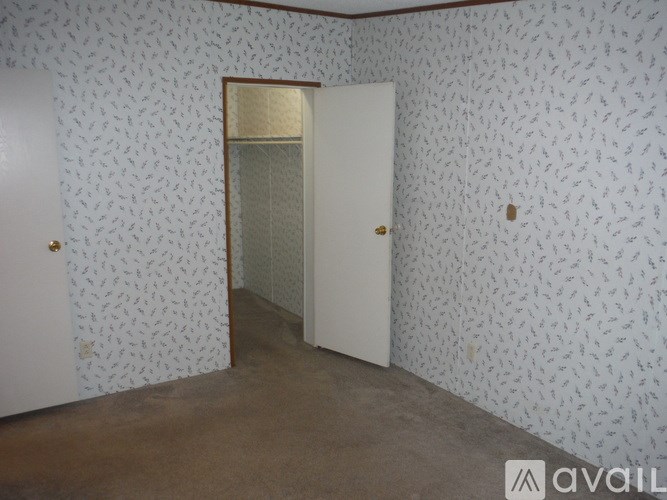 A room with a door and wallpaper.