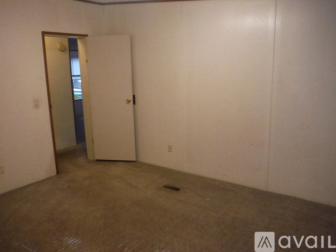 A room with a door and a wall with a hole in it.