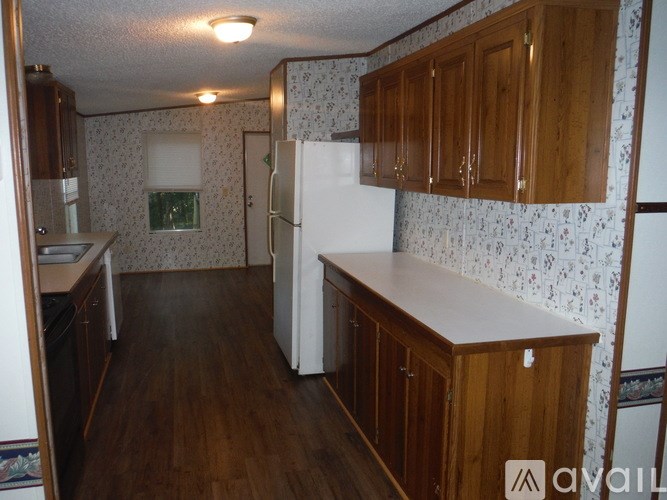 A kitchen with wooden cabinets and a white refrigerator.